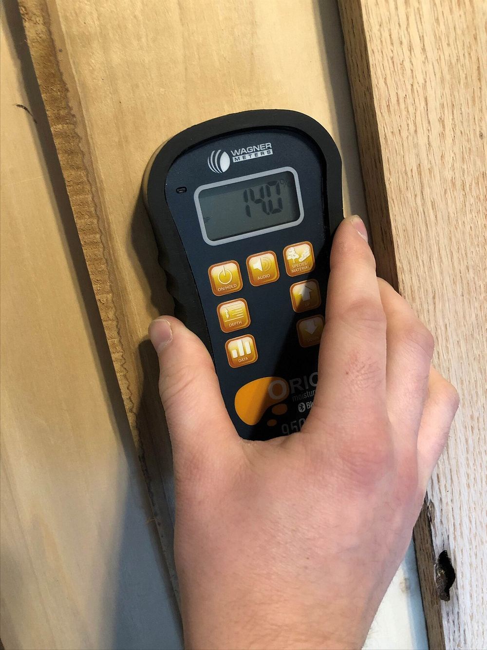 Fuktmätare mot en träyta, den typ av mätning som tillkommer i steg 2.