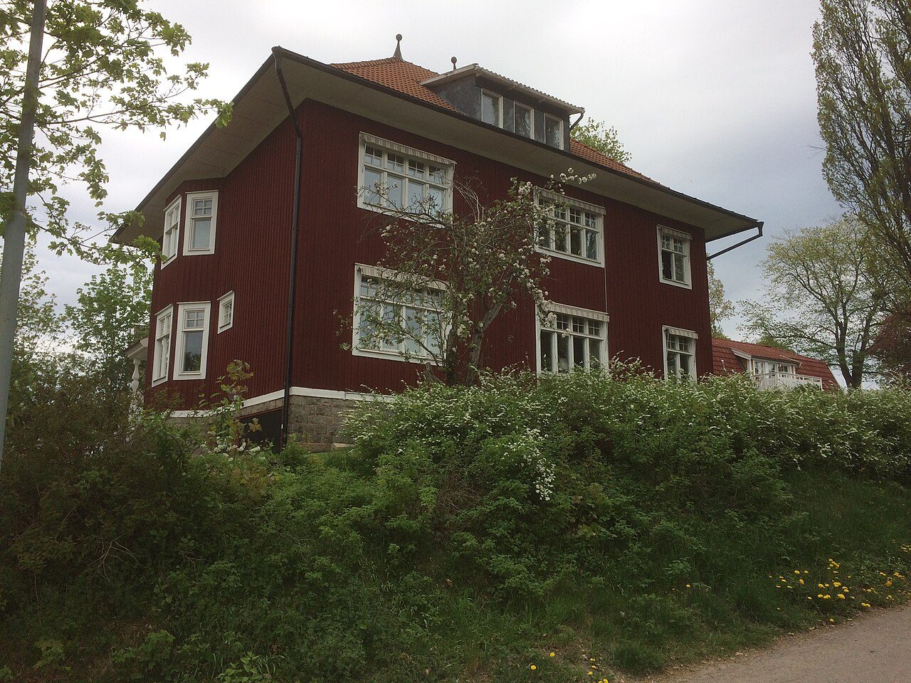 En röd trävilla på Bergalid i Falun, med vita fönster och tegeltak.